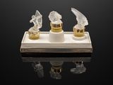 three crystal figurines of angels on a stand with a black background