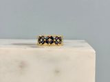 une photo d'une bague sertie d'un diamant noir posée sur un bloc de marbre