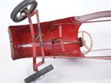 a red toy car with wheels on a white surface