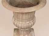 a stone planter sitting on a pedestal on a white background