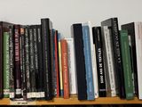 many books that are on a wooden shelf