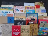 a pile of books on a table with a black background