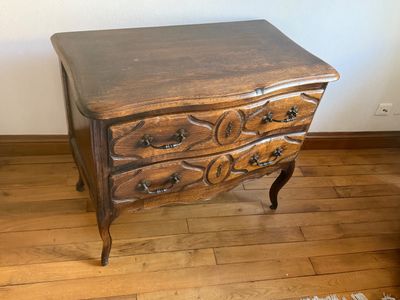 a small wooden chest of drawers on a wooden floor