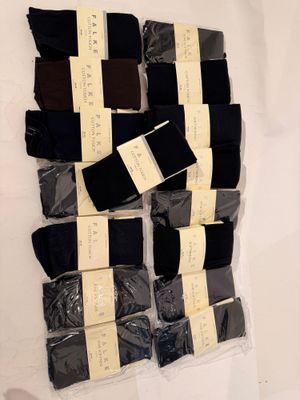 several pairs of men ' s black and brown socks on a white surface