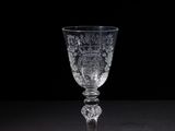 a wine glass sitting on a table with a black background