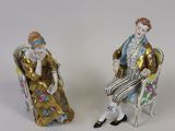 deux figurines représentant un homme et une femme assis sur une chaise