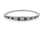 gros plan d'une bague en diamant et saphir sur une surface blanche