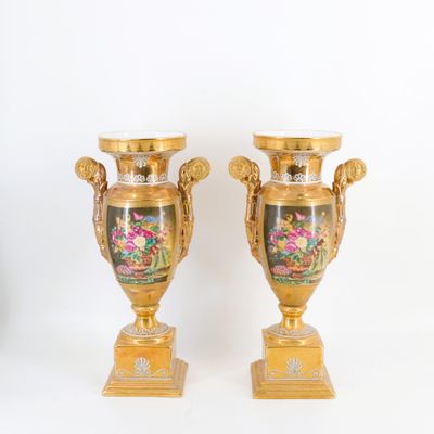 deux vases en or ornés de motifs floraux sur fond blanc