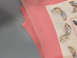 a stack of pink napkins with a picture of birds on them