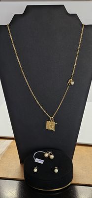 ensemble composé d'un collier et de boucles d'oreilles, exposé dans une vitrine