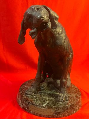 statue en bronze représentant un chien la gueule ouverte sur fond rouge