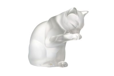 une figurine représentant un chat blanc posée sur une surface blanche