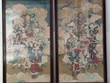 two framed paintings of oriental figures on a wall in a room