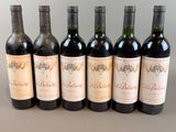 six bottles of wine are lined up in a row on a table