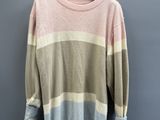 a pink and grey sweater hanging on a hanger