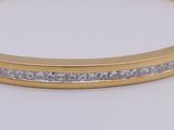 a close up of a gold bracelet with diamonds on it