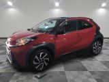 La Toyota C-HR rouge est garée sur un sol à damier.