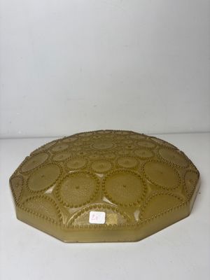 yellow glass plate with a decorative design on it on a white surface