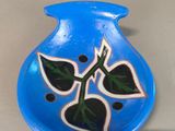 a blue vase with a flower on it on a table
