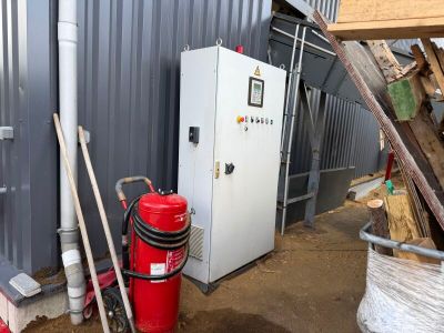 un extincteur rouge à côté d'un bâtiment métallique