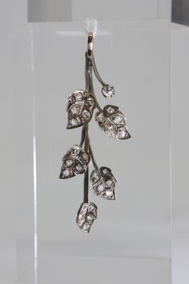 sterling silver leaf earrings with diamonds on a clear acrylic stand
