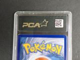 a pokemon card in a plastic case on a table