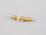 a close up of a gold and diamond broochle on a white background