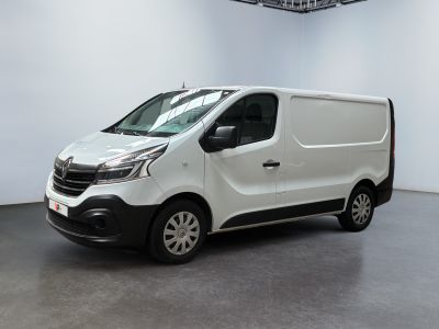 La camionnette blanche est garée dans une grande pièce blanche.