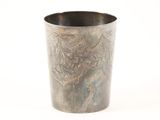 a metal cup with a design on it on a white surface