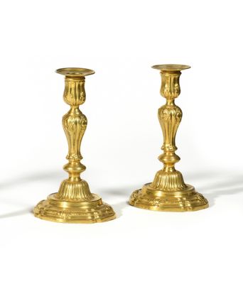 pair of antique brass candlesticks on a white background