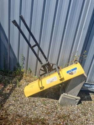 une image représentant une machine jaune appuyée contre un bâtiment