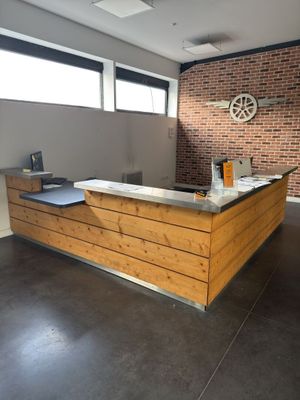 a wooden counter in a room with a brick wall behind it