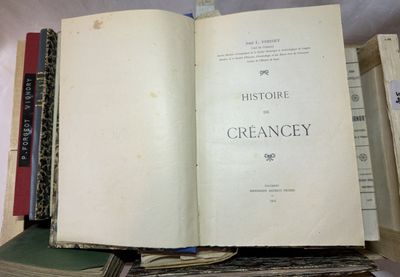 un livre ouvert posé au sommet d'une pile de livres
