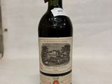 une vieille bouteille de vin posée sur une table blanche