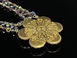 a close up of a necklace with a flower on it
