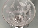 a clear glass bowl with a silver base on a table