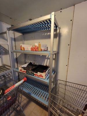 a metal shelf with baskets and bottles on it