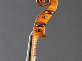 a close up of a violin on a stand against a gray background