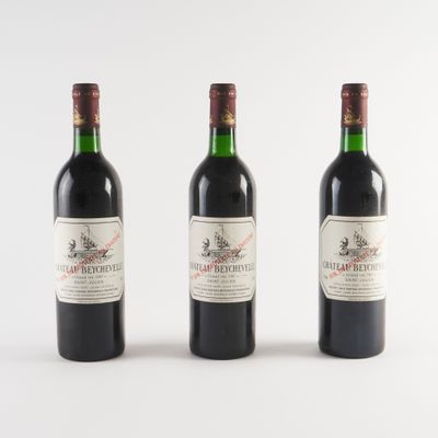 trois bouteilles de vin rouge sont alignées sur une surface blanche