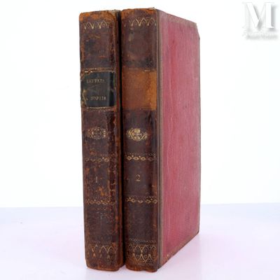 two old books sitting on top of each other on a table
