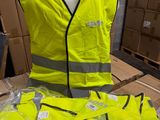 un mannequin portant un gilet de sécurité jaune à côté d'une pile de cartons