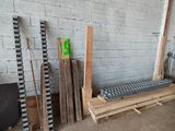 Plusieurs morceaux de bois sont empilés sur une palette, à côté d'un mur de briques