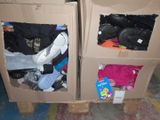 two cardboard boxes with clothes in them on a pallet