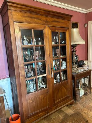 un grand meuble en bois avec des portes en verre dans une pièce