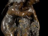 bronze statue of a boy and a girl with a basket of flowers