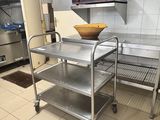 un chariot de cuisine en acier inoxydable muni d'un saladier sur le dessus
