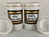 two white cups with gold trims are sitting next to each other