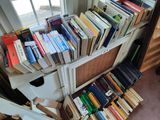 a lot of books that are stacked on a shelf