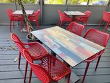 many red chairs and tables on the deck
