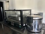 un plan de travail en acier inoxydable sur lequel sont posés une mijoteuse et un micro-ondes